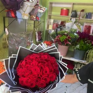 Grand bouquet dôme de roses rouges avec emballage sombre
