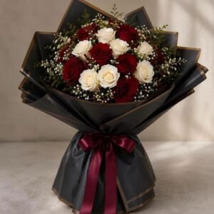 Un bouquet de luxe spectaculaire présentant un dôme de roses rouges souligné par une bordure perlée et un emballage architectural blanc plissé.